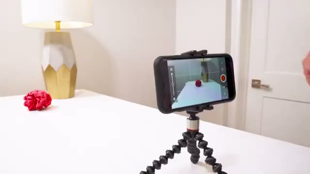 A smartphone on a small tripod filming a stop-motion shot